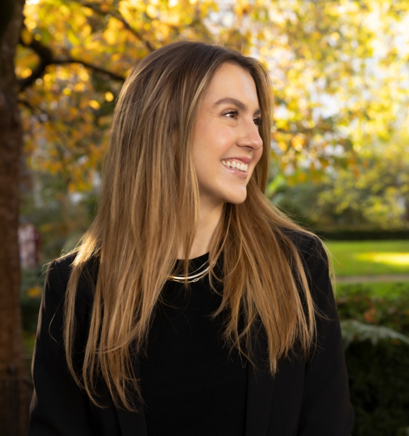 Natural headshot of Veronica Uribe looking off to the right standing outside