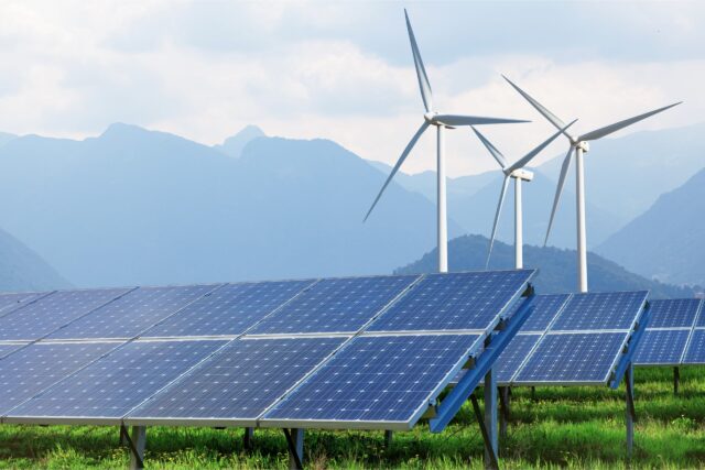 image depicting wind and solar renewable energy with mountains in the background
