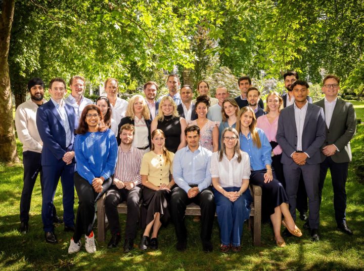 The entire Tribe team photographed standing outside with greenery in the background.